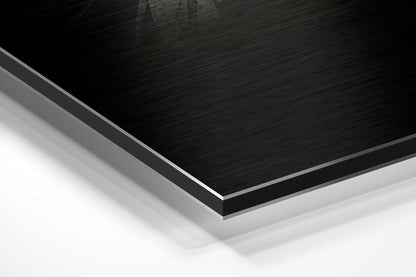 Close-up angled view of layered Dibond panel showing black brushed aluminium top surface with white backing layers.