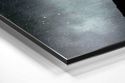 Angled close-up of layered brushed aluminum Dibond panel showing dark textured surface with white backing layers and black edge trim.