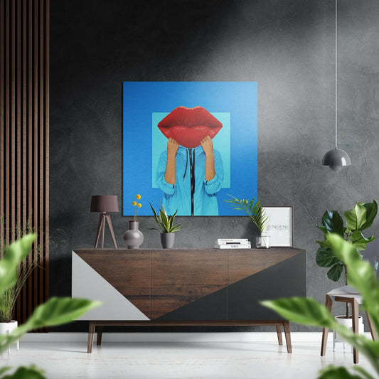 Modern interior displaying blue aluminum wall art featuring figure holding oversized red lips, mounted above wooden console table with accessories.