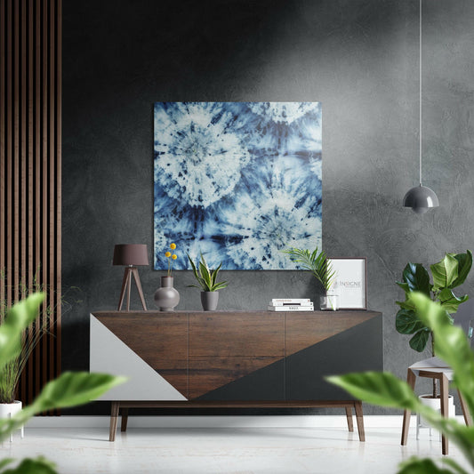 Blue and white tie-dye patterned brushed aluminium Dibond art displayed on grey wall above wooden sideboard in modern interior.