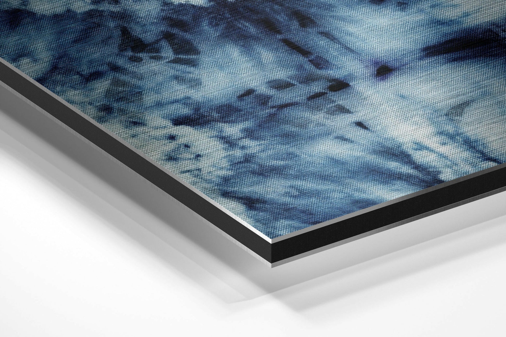 Close-up angled view of layered framing edges showing blue textured artwork with black and silver aluminum borders.