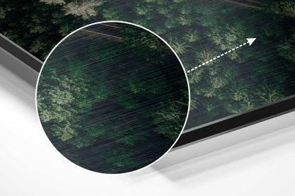 Overhead perspective of circular brushed aluminum wall art mounted on green forest canopy with directional arrow overlay.