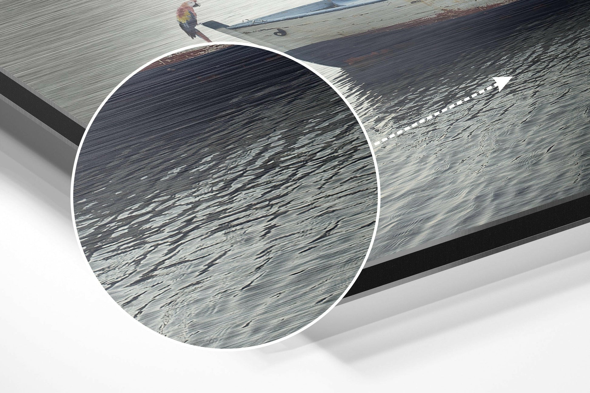 Close-up detail of brushed aluminum surface showing linear texture and grain patterns with water reflections and wooden dock in background.