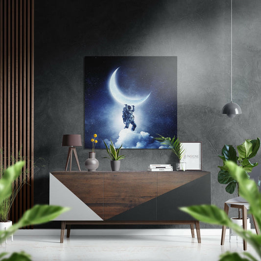 Modern living room interior with "Holding the Moon" artwork displayed above wooden console table with potted plants and pendant lamp.