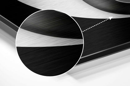 Close-up angled view of brushed aluminum wall art showing circular yin-yang design with black and white textured surfaces and white edge border.