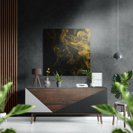 Black and gold abstract artwork displayed above wooden credenza in contemporary living room setting with plants and pendant light.