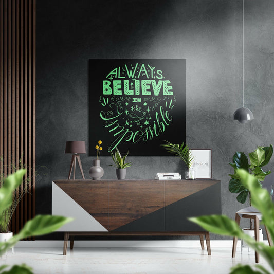 Black aluminum wall art with bright mint green inspirational lettering displayed above a wooden console table in a modern interior setting.