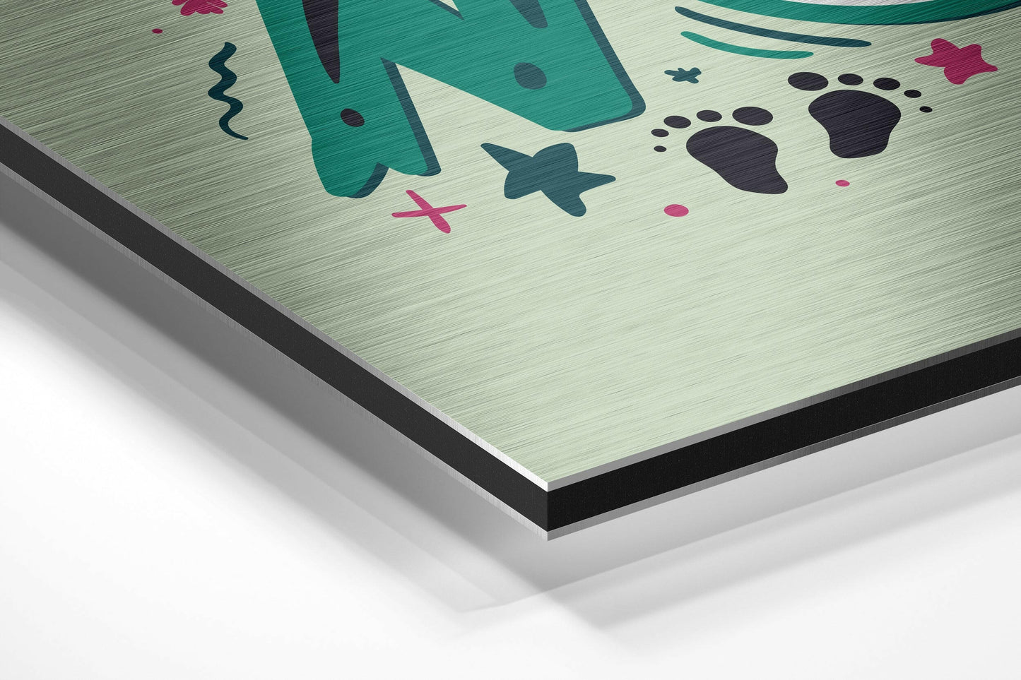 Close-up angled view of brushed aluminum composite panel with teal, pink, and black underwater-themed illustrations on light background.