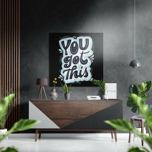 Modern interior display showing "You Got This" neon-style wall art in light blue and white lettering on black background above wooden dresser.