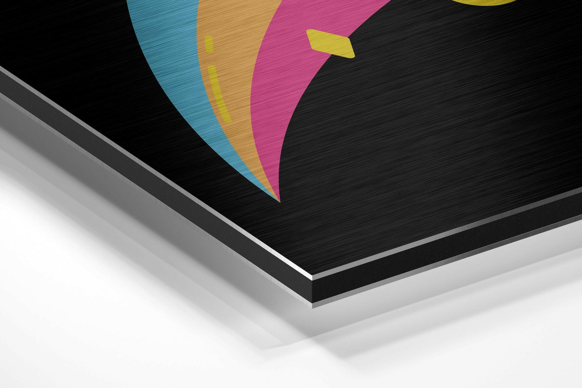 Angled perspective view of brushed aluminum dibond wall art featuring colorful geometric shapes in blue, gold, magenta, and yellow on black background.