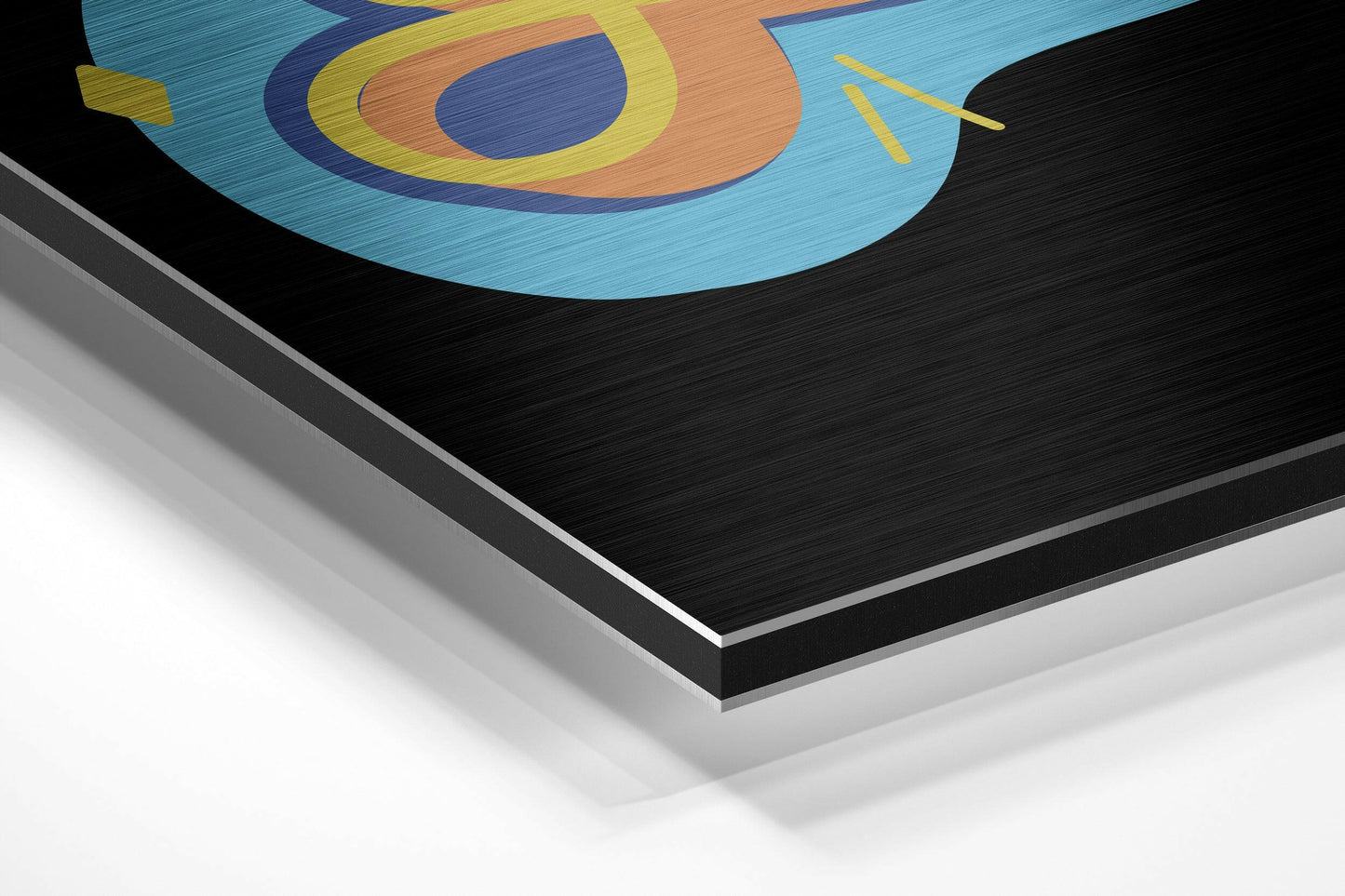 Close-up angled view of layered aluminum dibond wall art showing brushed metal edges and colorful geometric design with concentric circles in blue, yellow, orange, and navy.