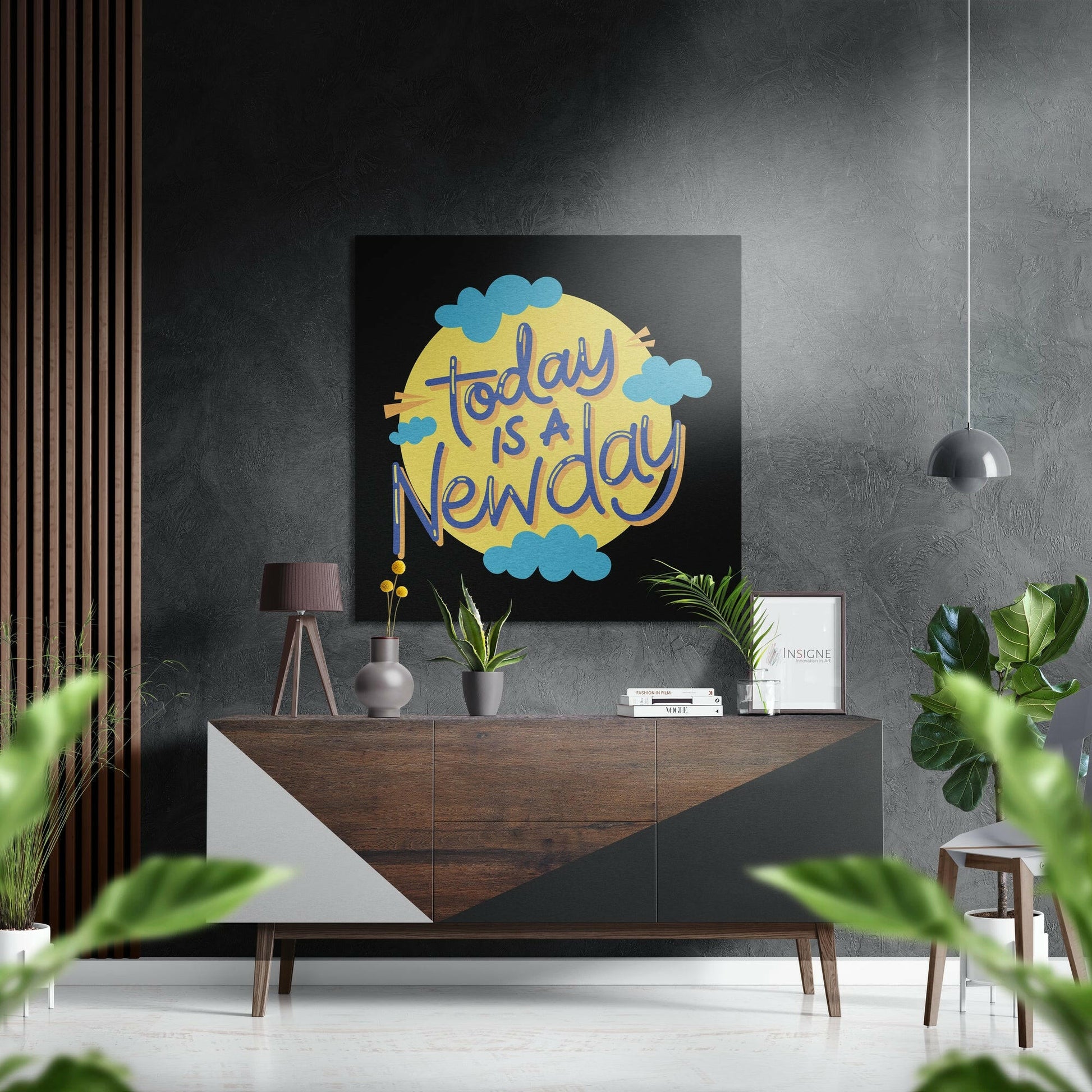 Motivational wall art displaying "Today is a New Day" in blue text on yellow sun with blue clouds, mounted above wooden dresser in modern interior.