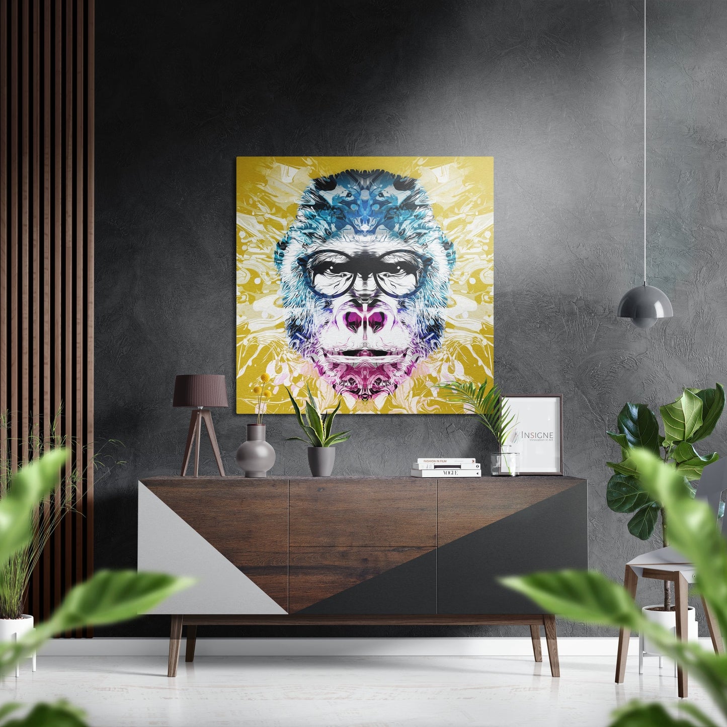 Colorful pop art monkey portrait with glasses and pink accents displayed above mid-century wooden console in modern grey interior.