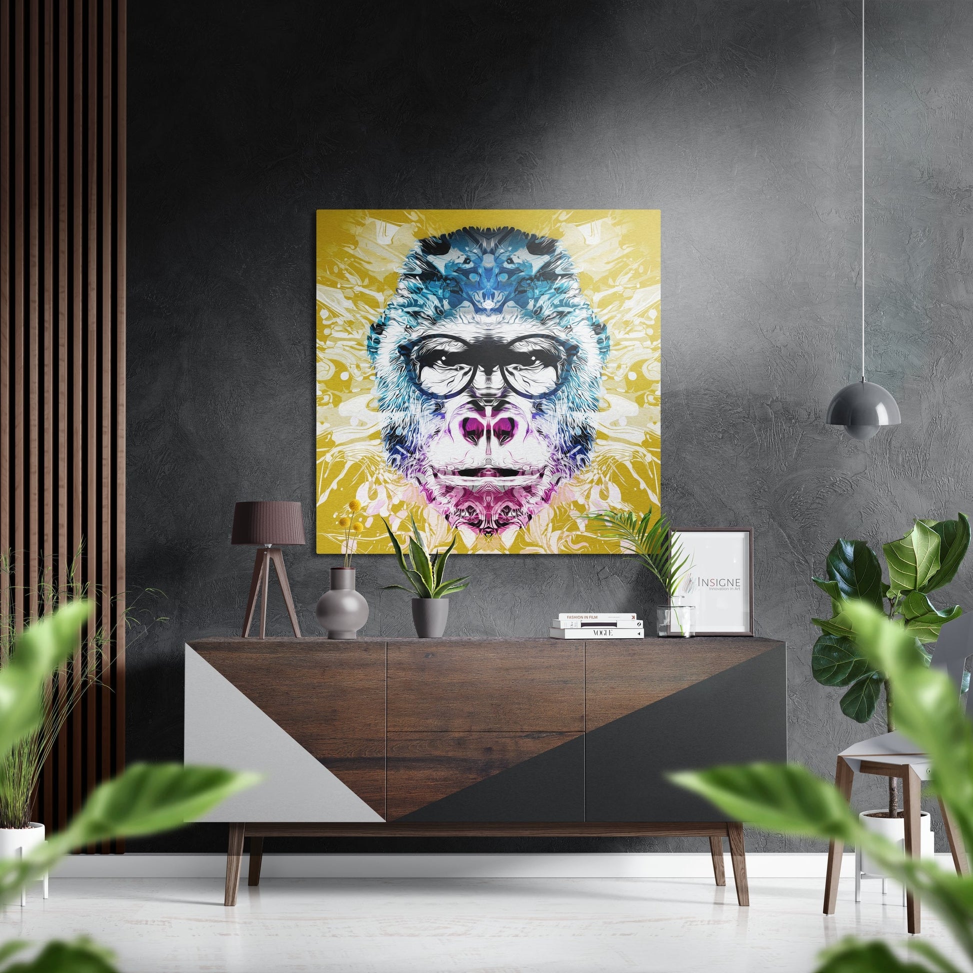 Colorful pop art monkey portrait with glasses and pink accents displayed above mid-century wooden console in modern grey interior.