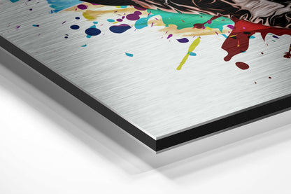Angled perspective view of brushed aluminium dibond panel with colorful paint splatters and abstract dog artwork in teal, purple, yellow, and red tones.