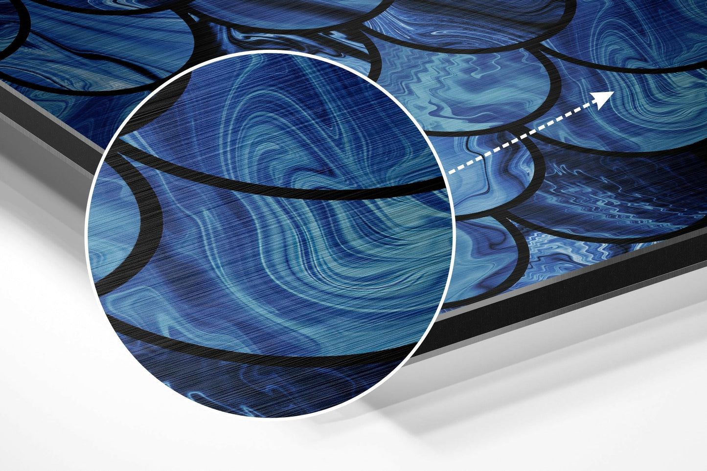 Close-up detail of blue brushed aluminium wall art showing swirling liquid patterns with black curved lines and magnification circle.