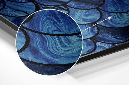 Close-up detail of blue brushed aluminium wall art showing swirling liquid patterns with black curved lines and magnification circle.