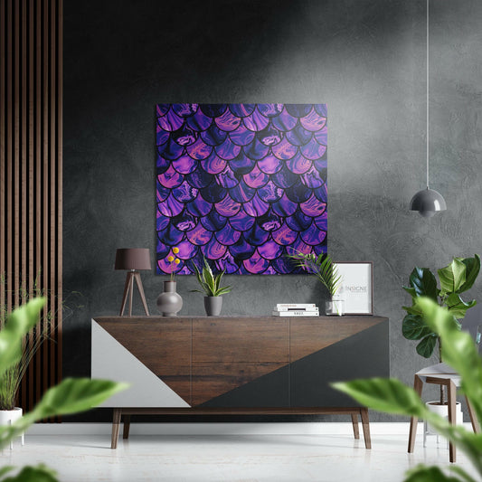 Purple and pink iridescent scale pattern artwork displayed above wooden sideboard in modern living room with grey walls and green plants.