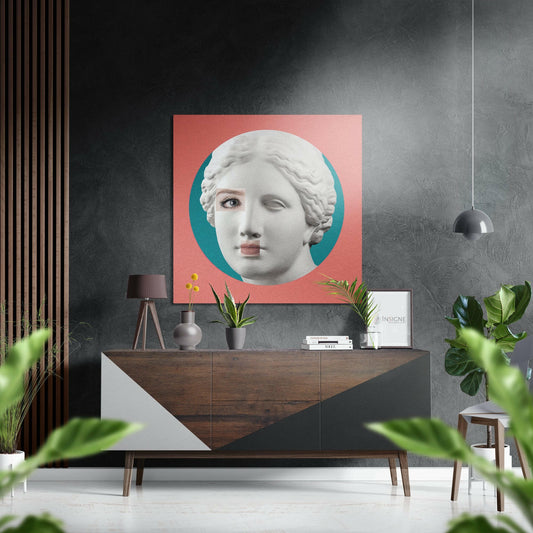 Modern interior with coral and teal goddess bust artwork displayed above wooden console table with plants and decor.