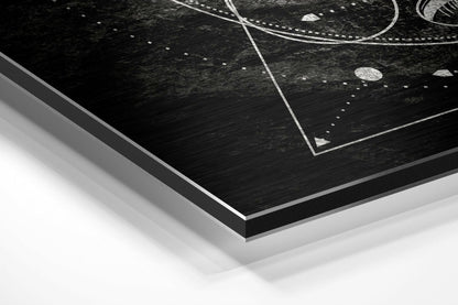 Angled corner view of black brushed aluminum Dibond wall art with white geometric line patterns and dotted details on dark textured surface.