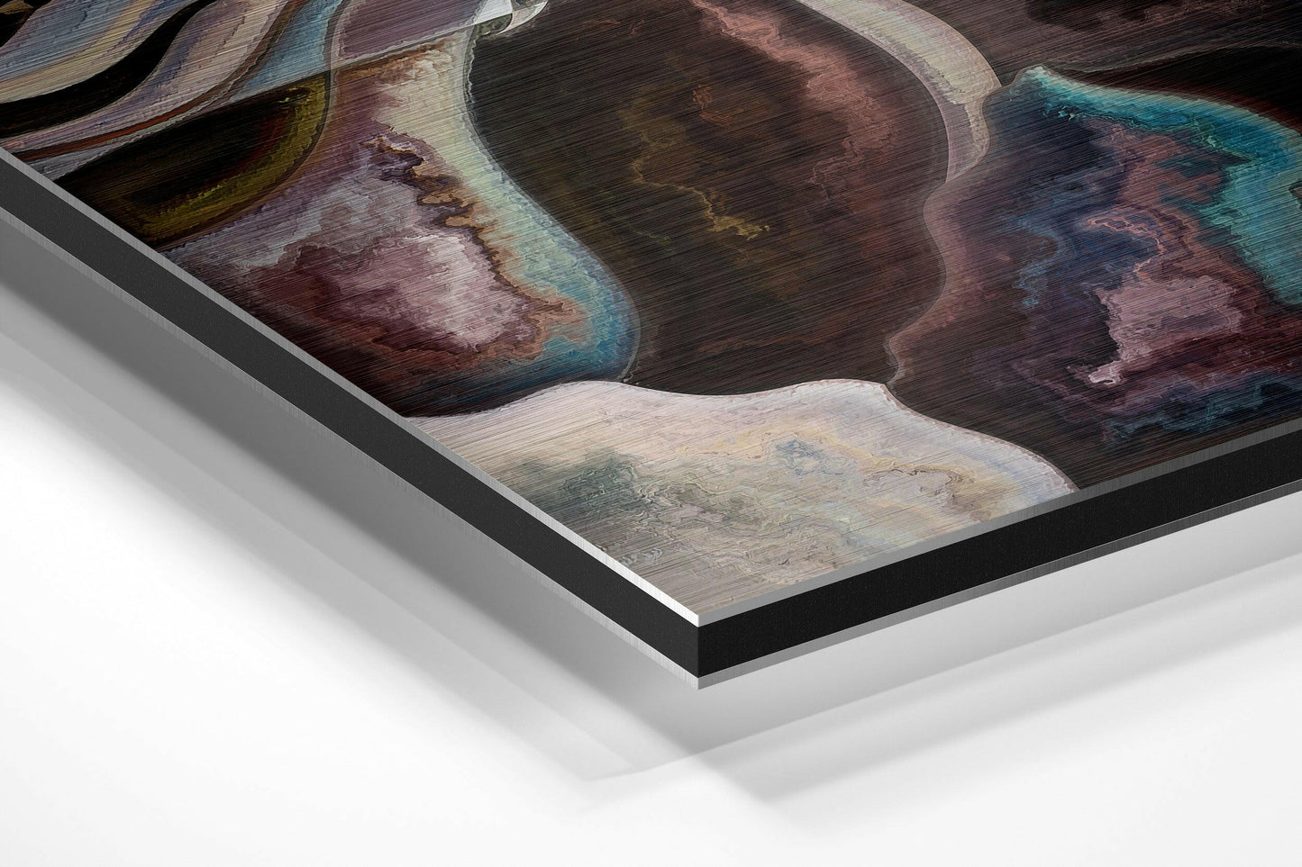 Angled perspective view of framed brushed aluminium wall art displaying abstract organic shapes in deep browns, teals, and cream tones.
