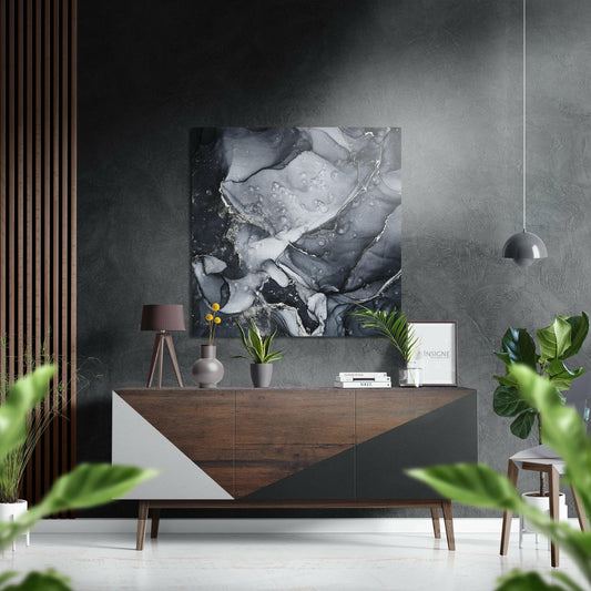 Black and silver marble abstract Dibond artwork hung above wooden dresser in modern interior setting with plants and decor.