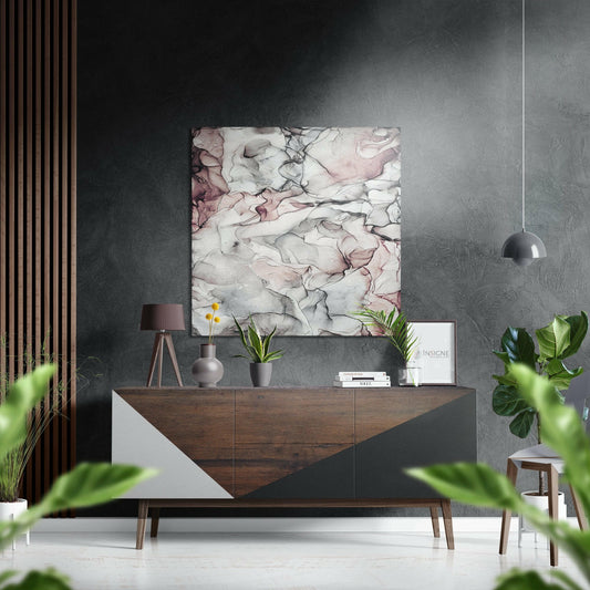 Modern interior showroom featuring white and pink marbled abstract art displayed above a wooden sideboard with decorative accessories and plants.