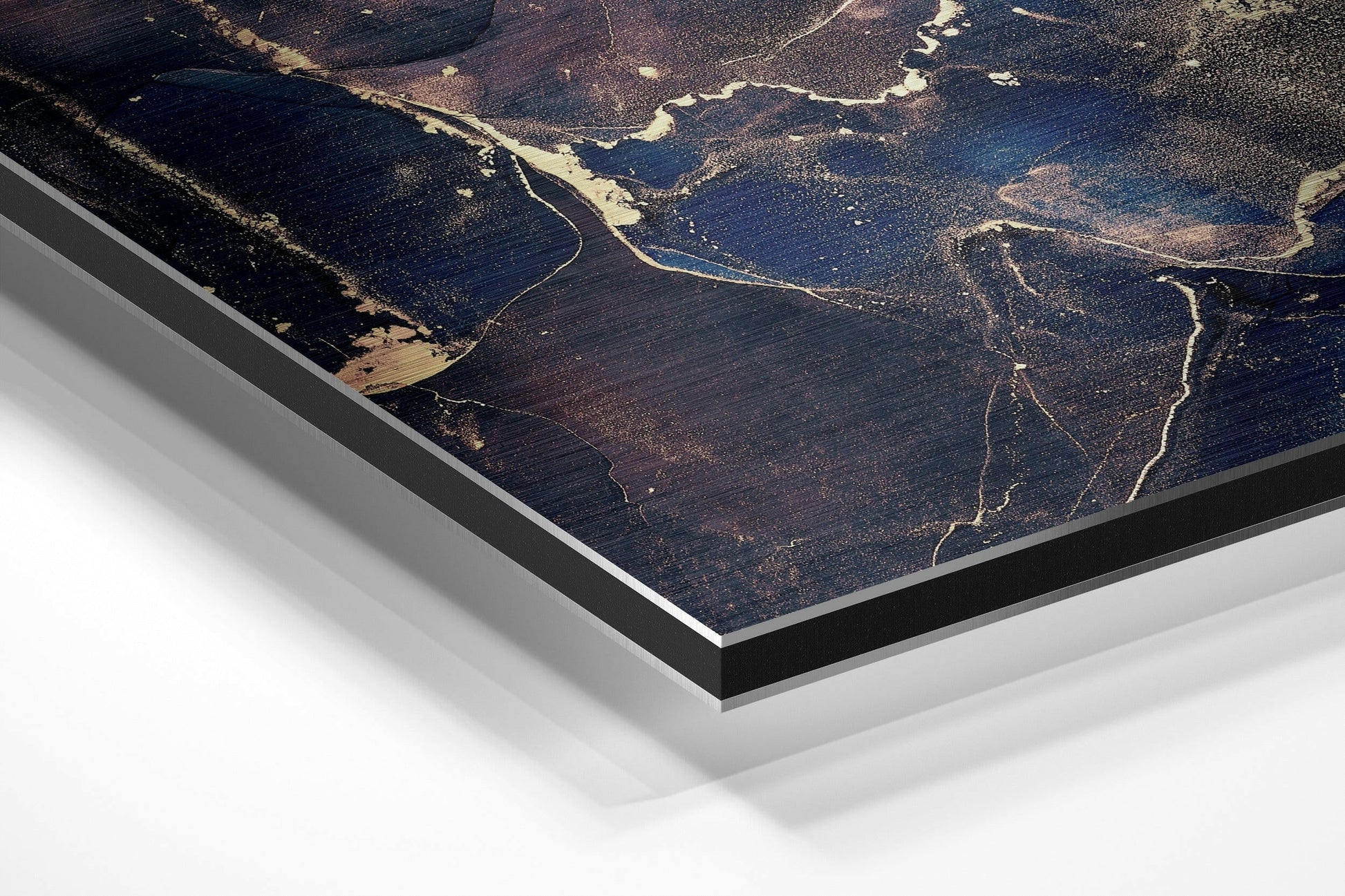 Angled close-up of brushed aluminium Dibond wall art showing aerial landscape with winding rivers, dark forests, and golden light reflections.