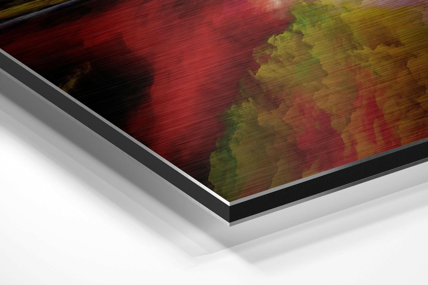 Angled perspective view of brushed aluminum Dibond wall art featuring red, yellow, and green abstract cloud patterns with black border and white backing.