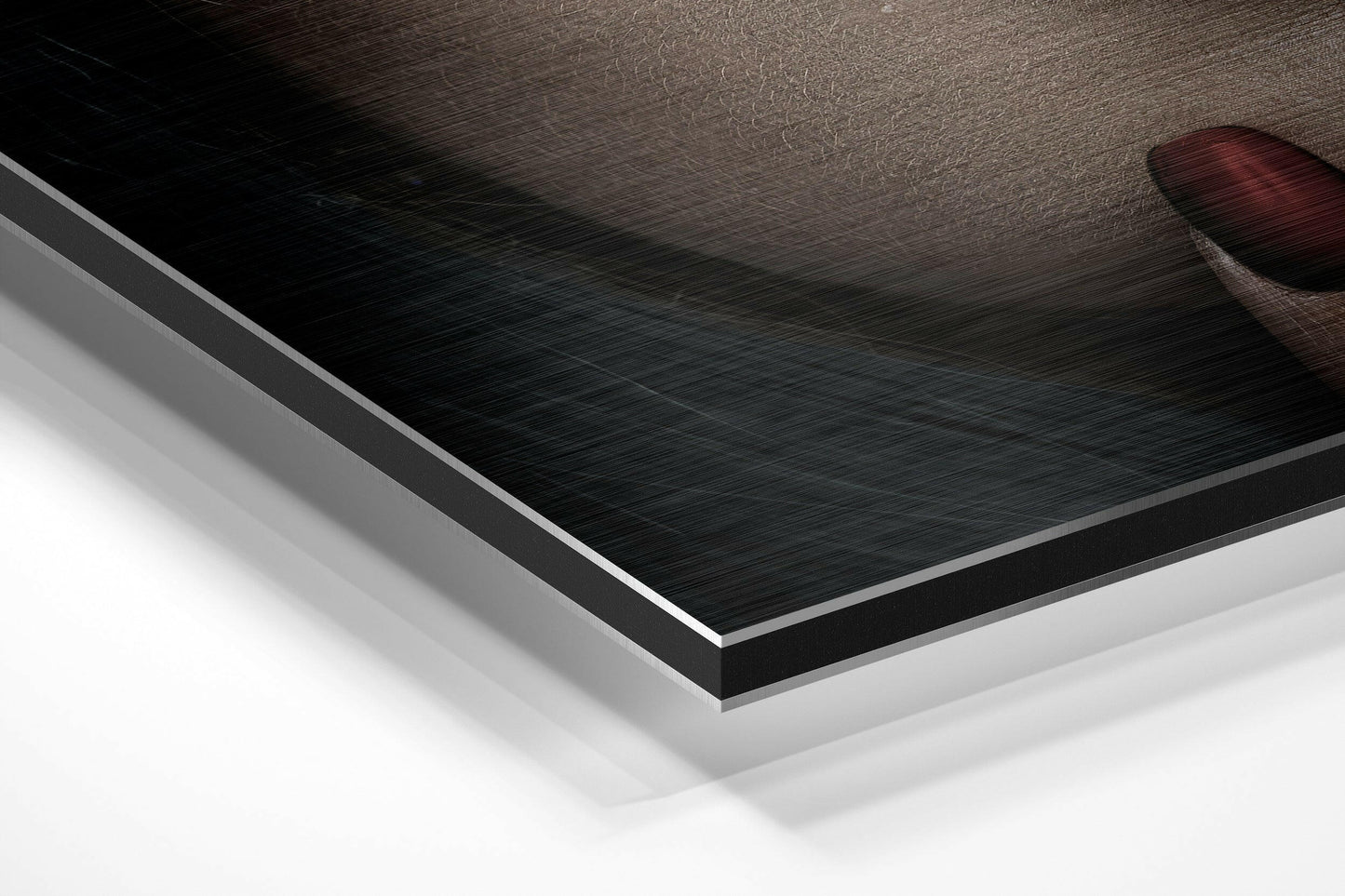 Layered diagonal view of brushed aluminum Dibond wall art showing textured black surface with white backing and silver edge trim.