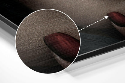 Close-up detail view of brushed aluminum surface with dark burgundy circular abstract shape and directional arrow overlay.