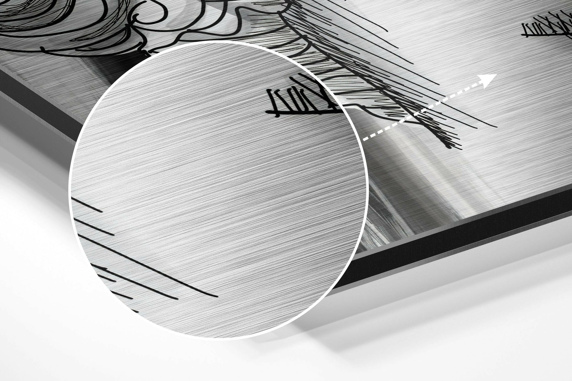 Close-up angled view of brushed aluminium Dibond sheet showing metallic surface texture with black artistic line drawings and white circular design element.