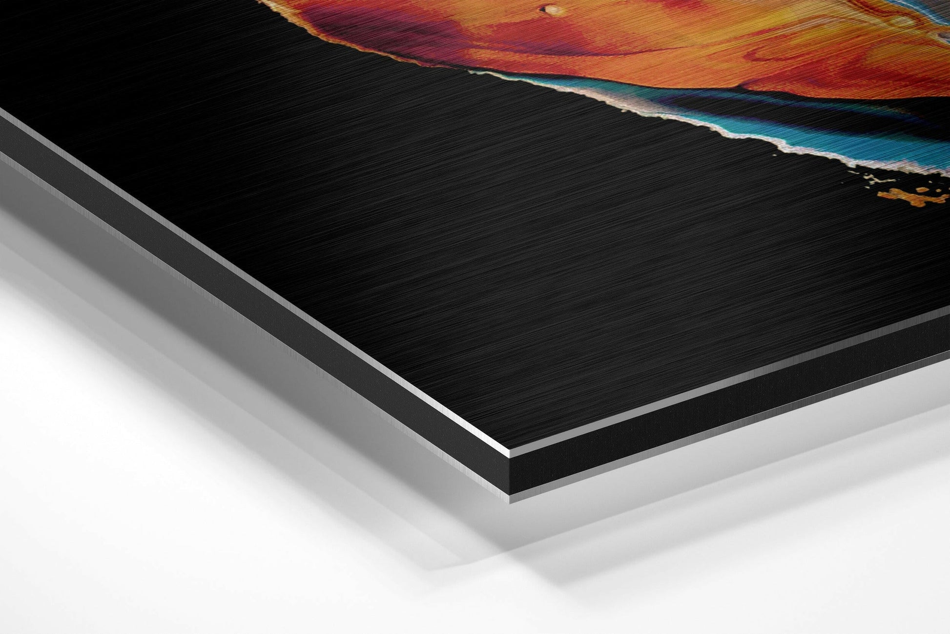 Angled perspective view of brushed aluminum Dibond art showing layered edge detail with orange, red, and teal abstract artwork visible on top surface.