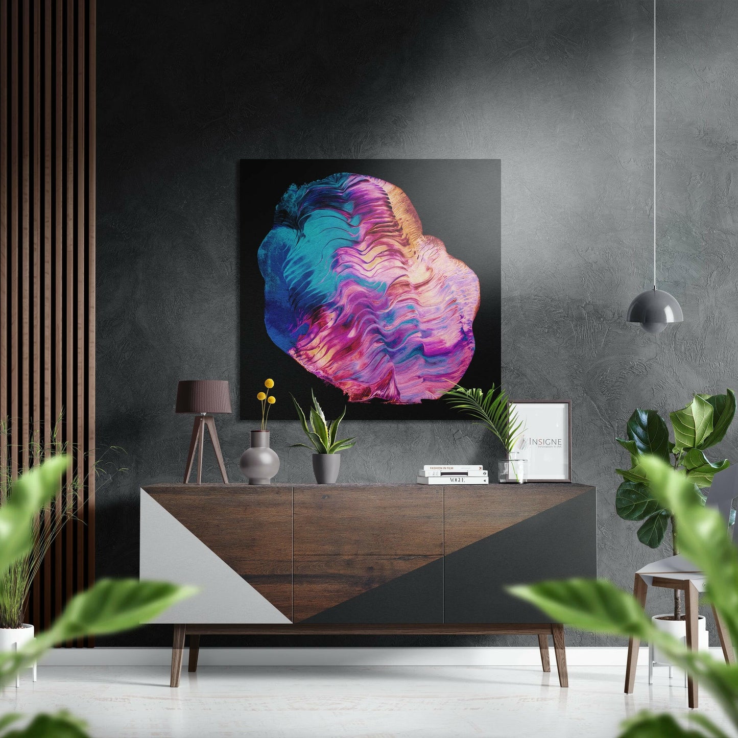 Vibrant abstract brushstroke artwork with blue, pink, and gold swirls displayed above a wooden console table in a modern interior setting.