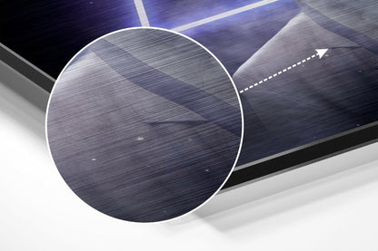 Angled close-up view of brushed aluminum wall art featuring a large white-outlined circle and directional arrow on blue and gray textured surface.