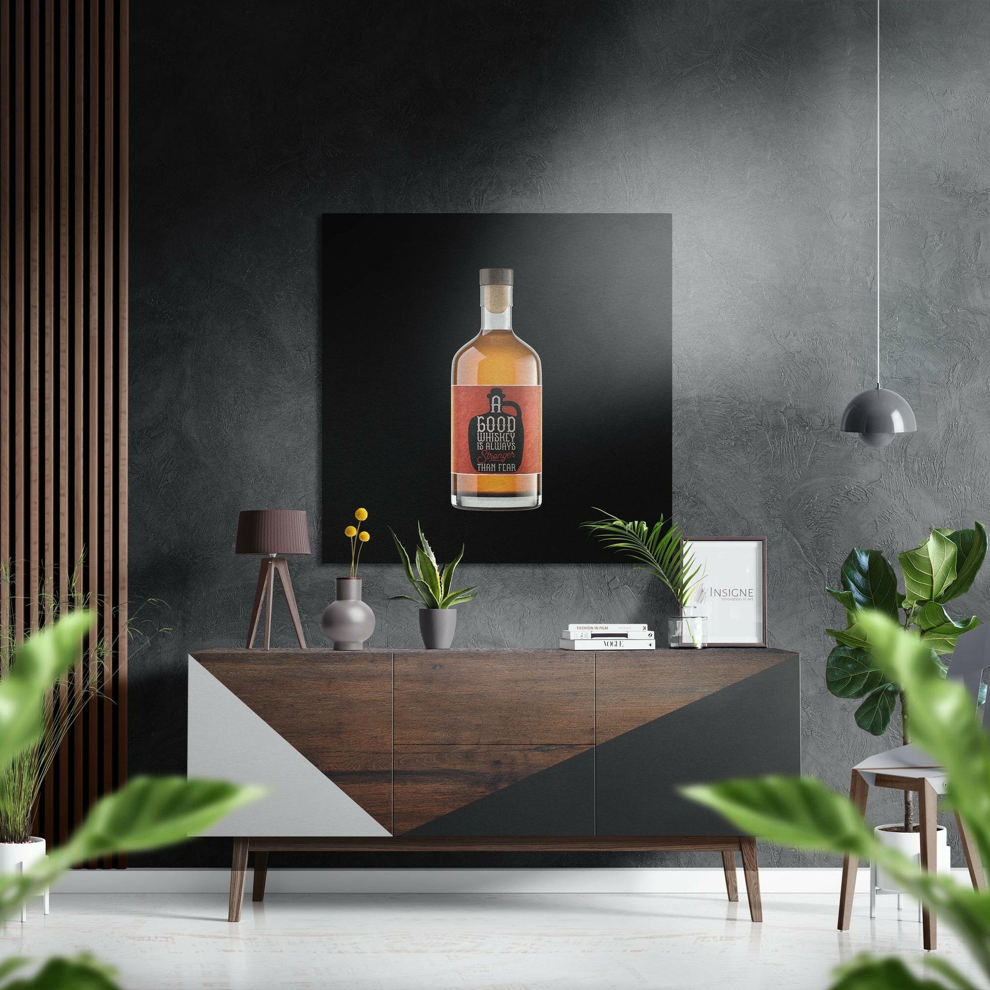 Modern interior with "Good Whiskey is Worth More Than Fear" whiskey bottle art displayed on black Dibond panel above mid-century wooden console.