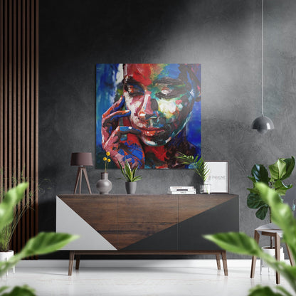 Colorful abstract portrait with red, blue, and yellow brushstrokes displayed above a mid-century wooden console in a modern gray interior.