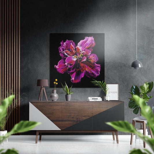 Magenta peony painting displayed on dark gray wall above wooden console table in modern interior setting with plants and pendant lamp.