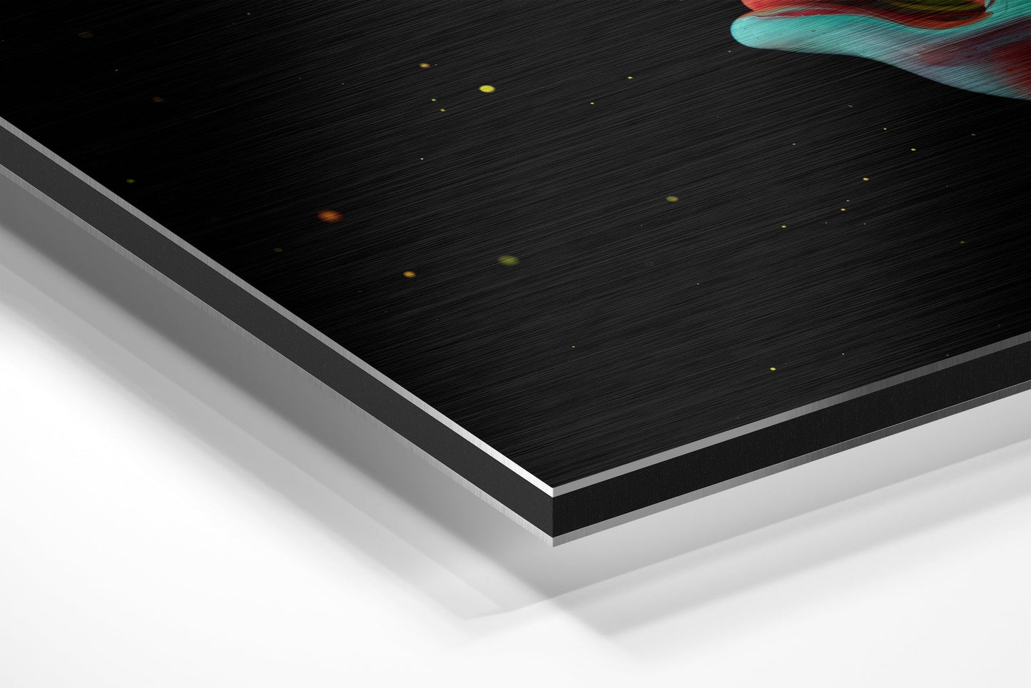 Close-up angled view of layered Dibond panel showing brushed black surface with white and gray backing layers, scattered colored light reflections visible on top.
