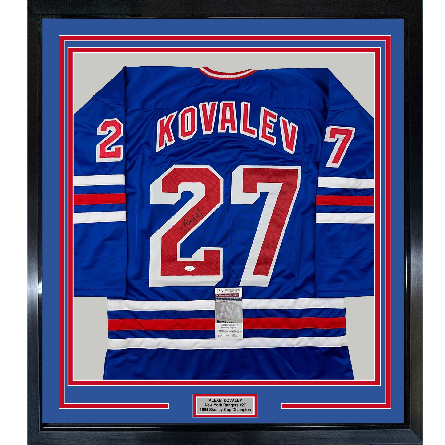 Framed blue New York Rangers jersey #27 signed by Kovalev, displayed front-facing with red and white stripes and JSA authentication certificate visible.