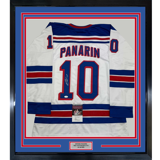 Framed white New York Rangers hockey jersey #10 with "PANARIN" and autographed number, displayed flat against blue and red matting with JSA certification label visible.