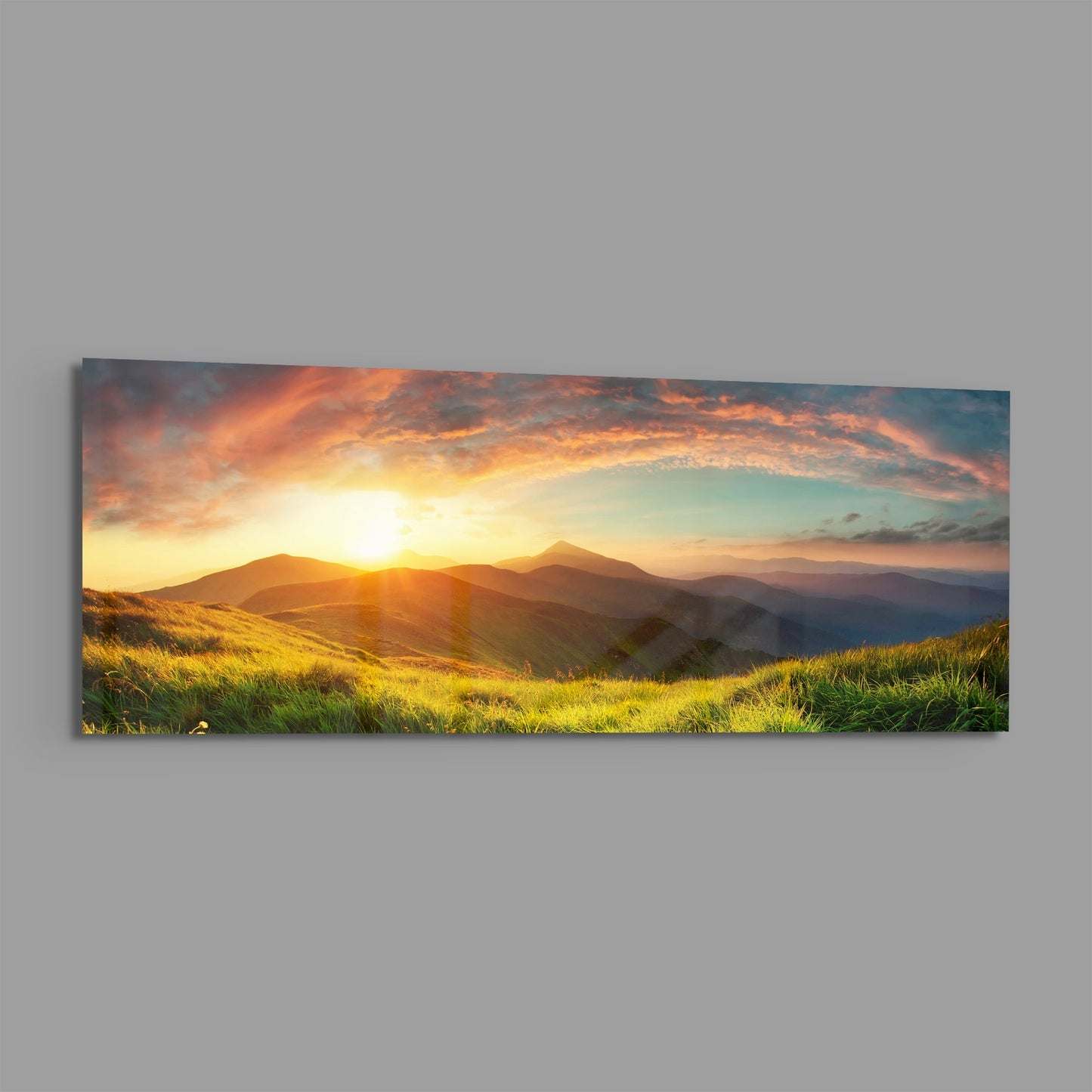 Golden sunrise over rolling green hills and distant mountains with dramatic orange and pink clouds in a panoramic glass wall panel.