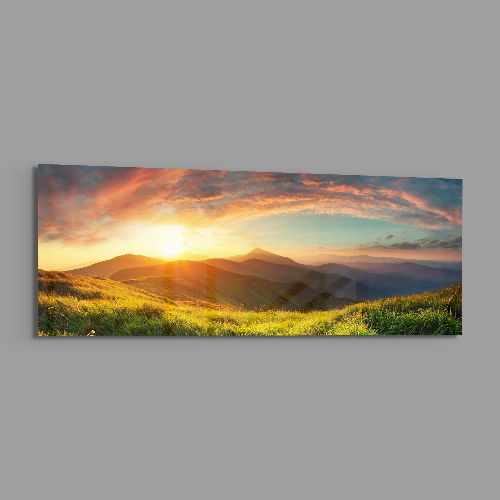 Golden sunrise over rolling green hills and distant mountains with dramatic orange and pink clouds in a panoramic glass wall panel.