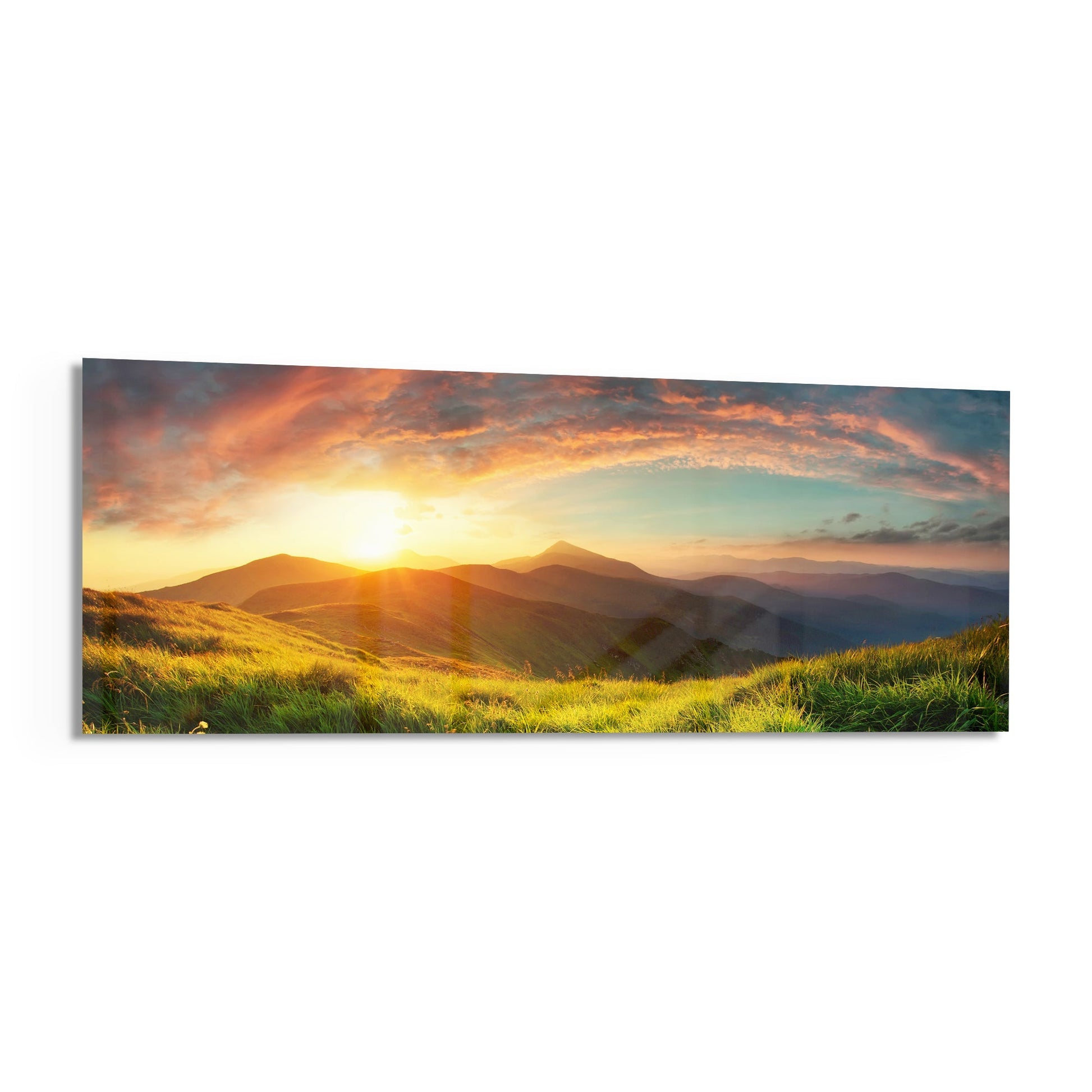Golden sunrise over rolling green hills and distant mountains with dramatic orange and yellow clouds.