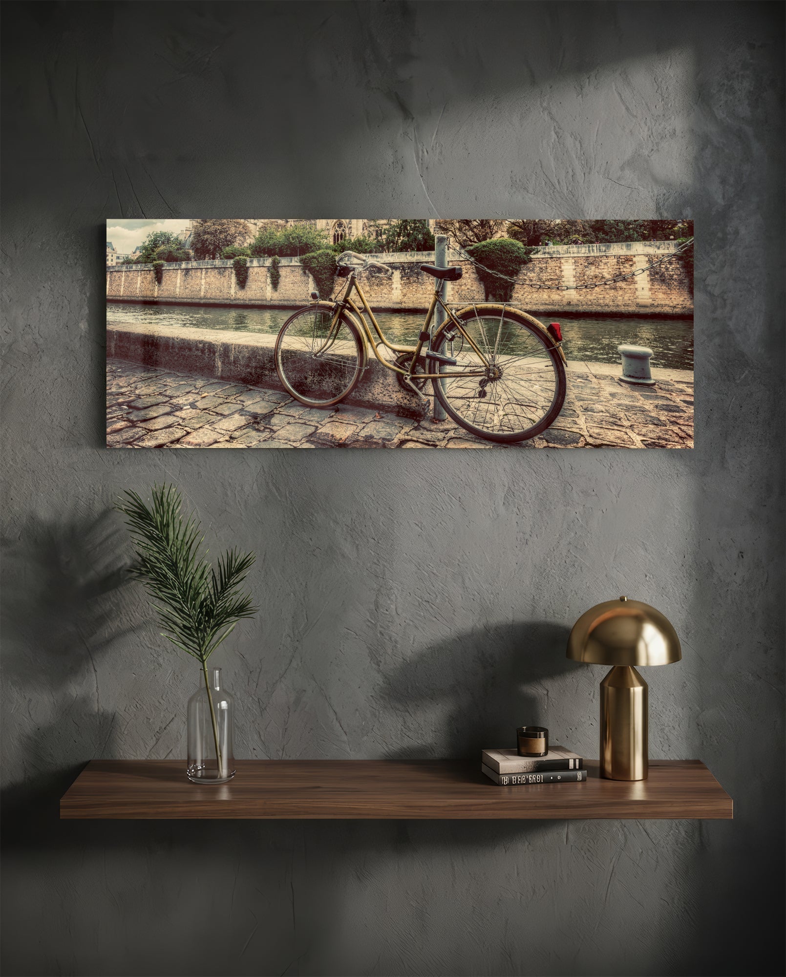 Vintage bicycle leaning against stone waterside wall with sepia-toned architectural background, displayed as horizontal glass wall art above wooden shelf.
