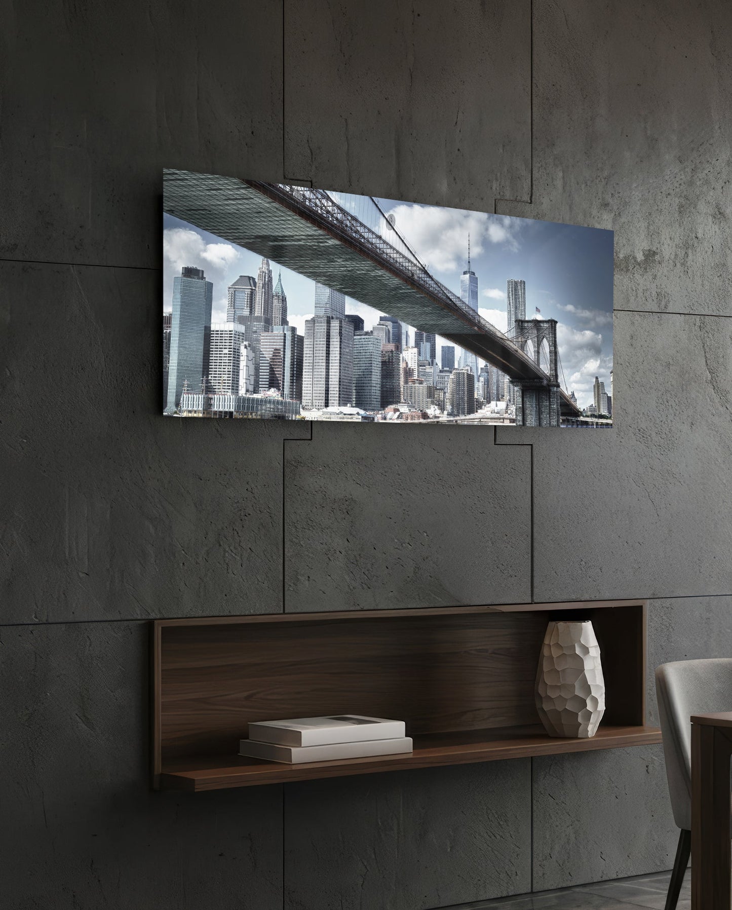 Brooklyn Bridge glass wall art mounted on concrete wall above wooden shelf, displaying NYC skyline and bridge structure in daylight.