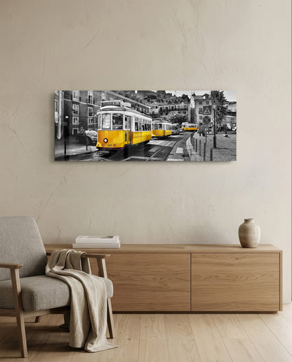 Yellow tram in black-and-white cityscape mounted on beige wall above wooden dresser in minimalist room.
