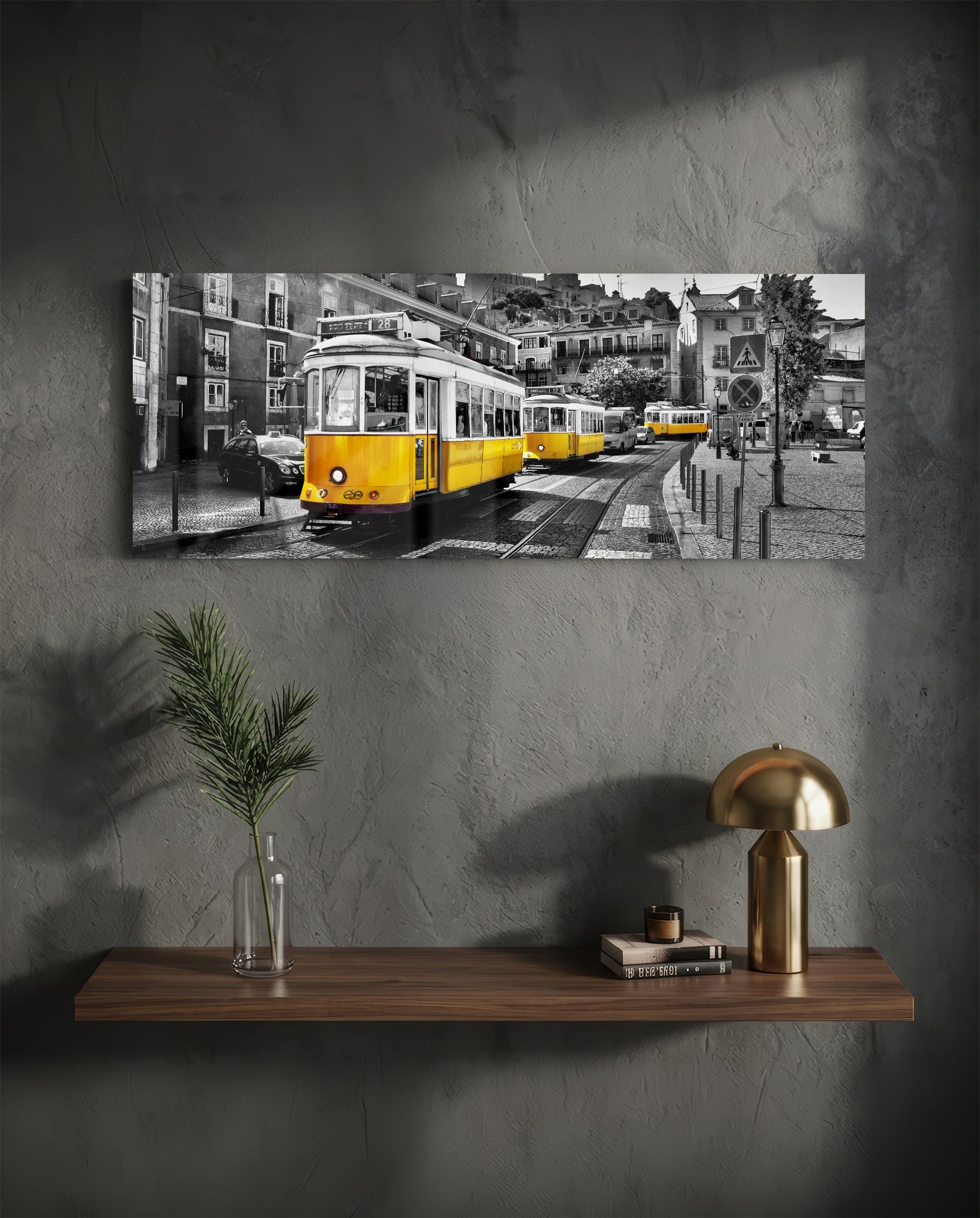 Yellow and black tram on cobblestone street with European buildings, displayed as horizontal glass wall art above wooden shelf.