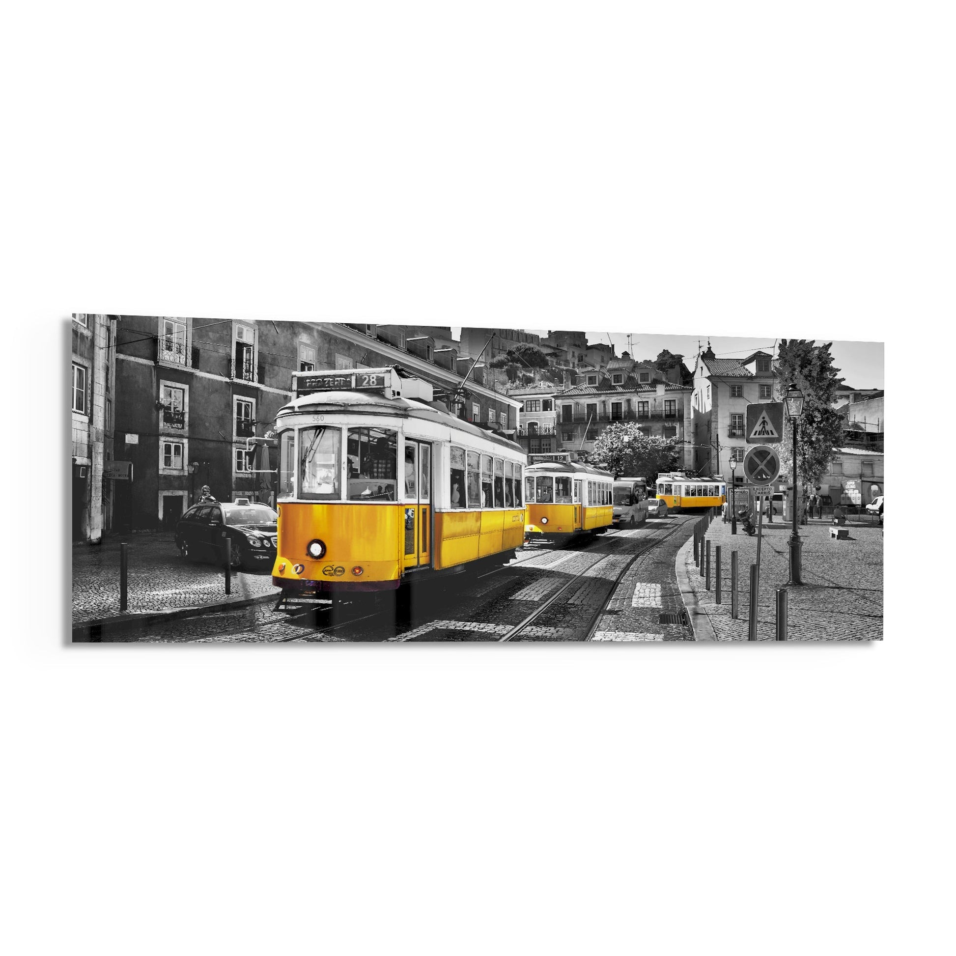 Yellow vintage trams on Lisbon street tracks with selective color effect against black and white architecture and buildings.