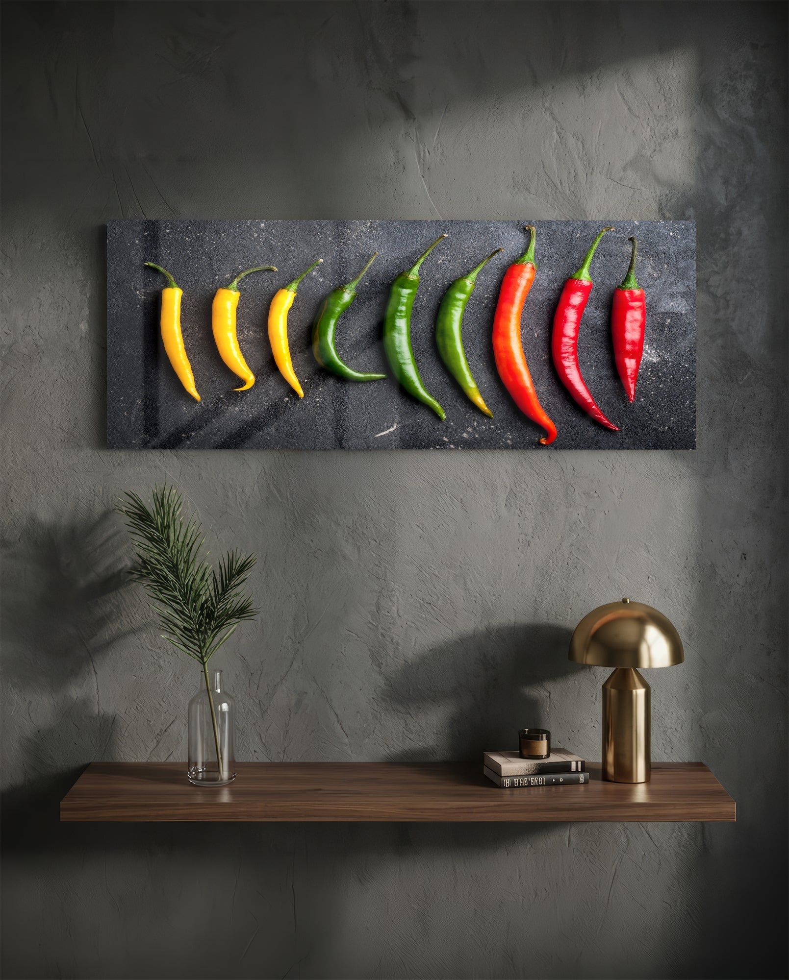 Nine chili peppers in yellow, green, and red gradient arranged on dark slate board mounted above wooden shelf with brass lamp and accessories.